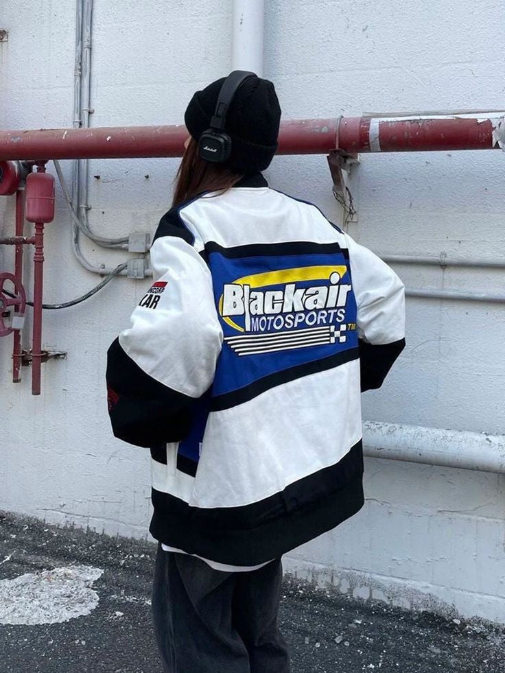 The back view of the vintage Blackair racer jacket, showcasing a large graphic design that includes retro branding and adds a classic motorsport flair to the overall look.
