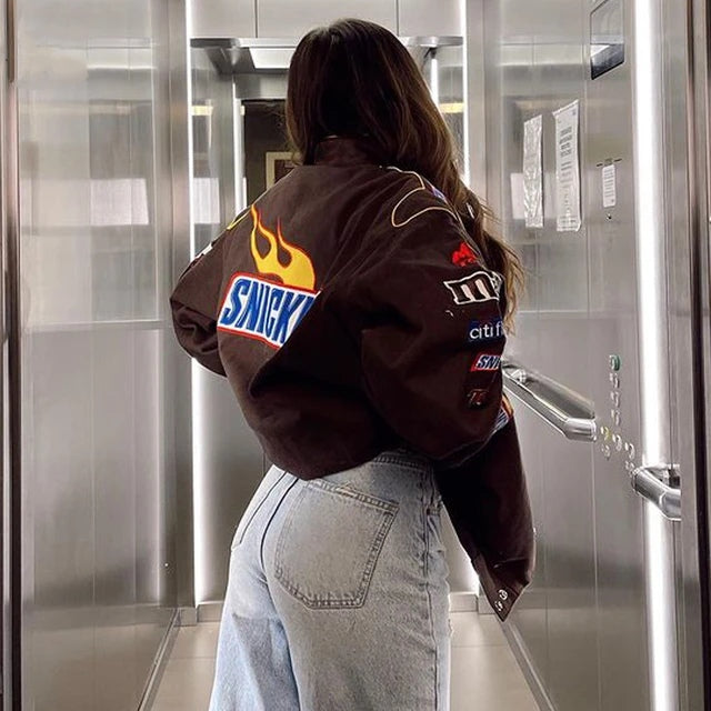 The back view of the vintage Snickers racer jacket, showcasing a large Snickers logo and additional racing graphics that enhance its classic motorsport appeal.