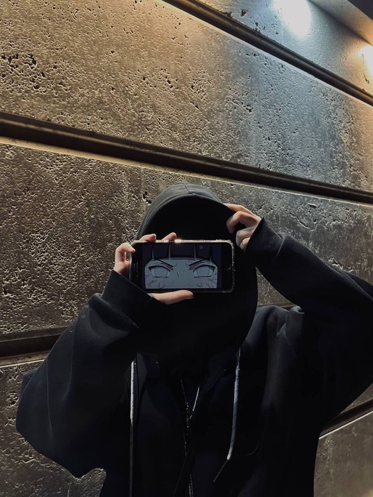 Unisex black balaclava hoodie outfit with zip-up front, styled with grunge pants and a black leather shoulder bag.