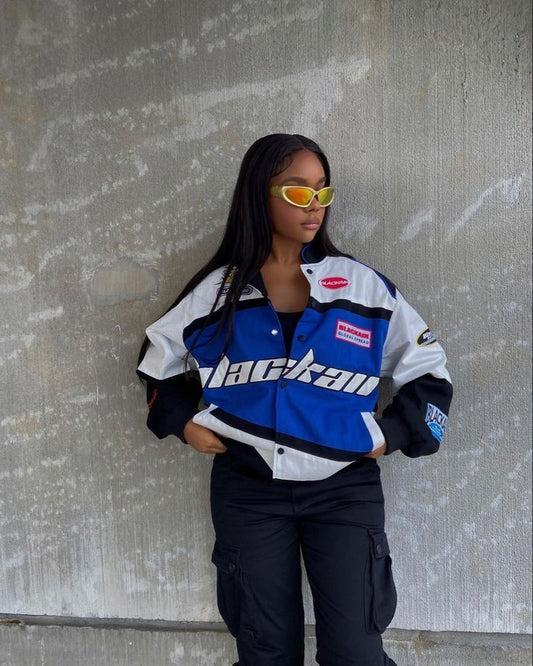 A model wearing the vintage Blackair racer jacket, styled with fitted jeans and sneakers, demonstrating the oversized fit and fashionable appeal in an urban environment.