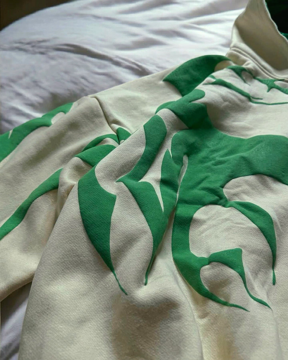 White shirt with green leaf pattern on a white background