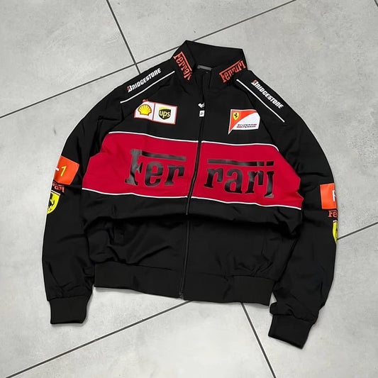 Black Ferrari jacket with red and white details on a gray tiled floor