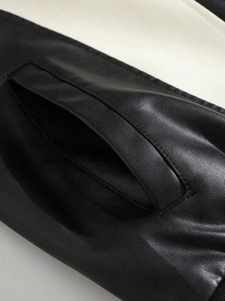 Close-up of a black leather jacket with a zipper on a light background