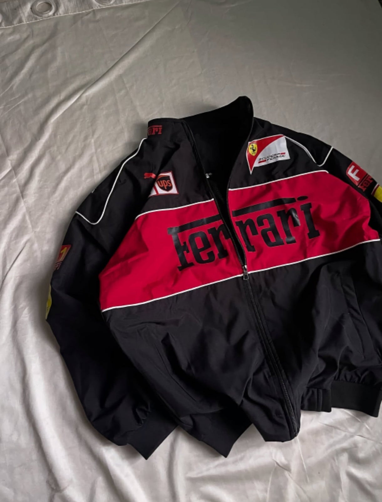 Black and red Ferrari jacket on a light gray background