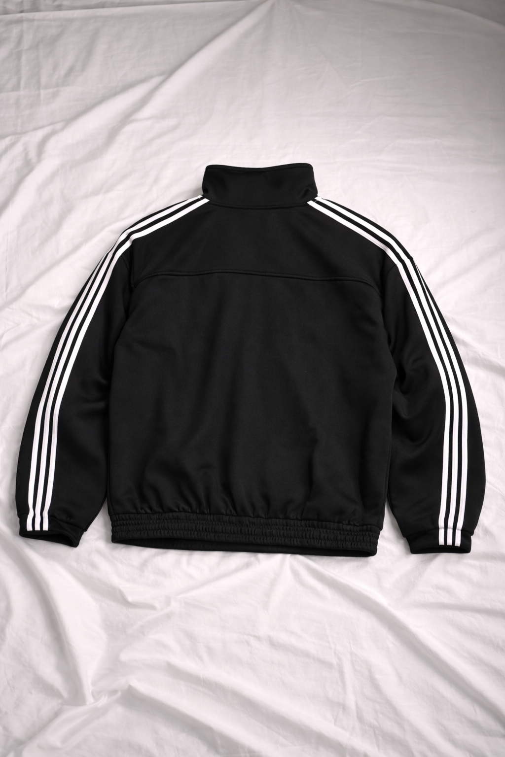 Black CNY jacket with white stripes on a white background