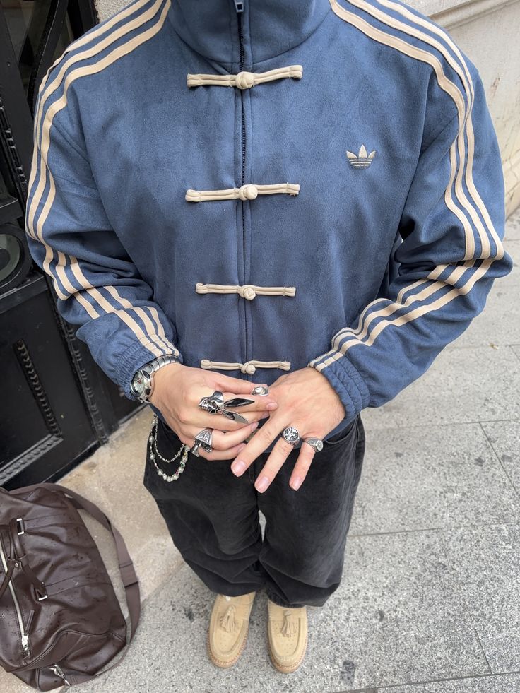 Person wearing a blue CNY jacket with white stripes on a sidewalk.