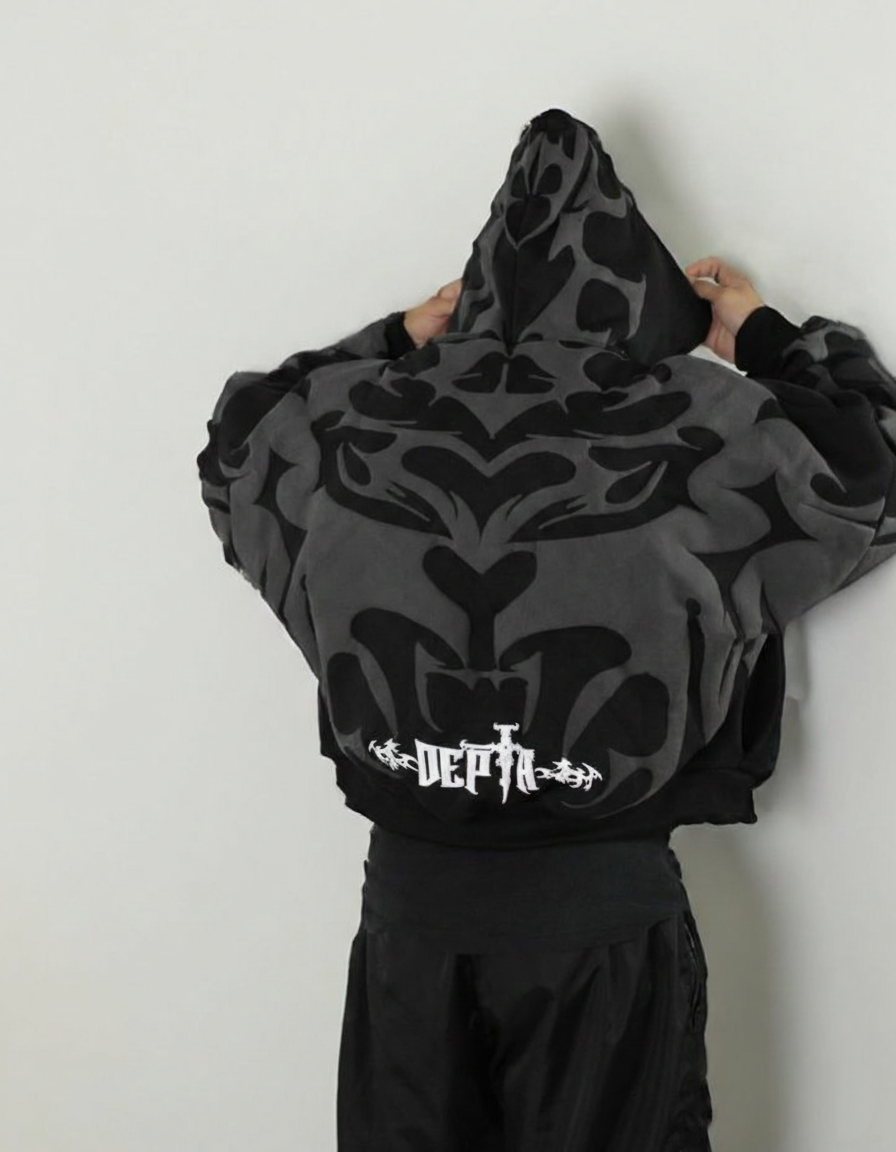 Person wearing a black and gray Depth Hoodie Y2k patterned hoodie with 'DEATH' logo on a plain background