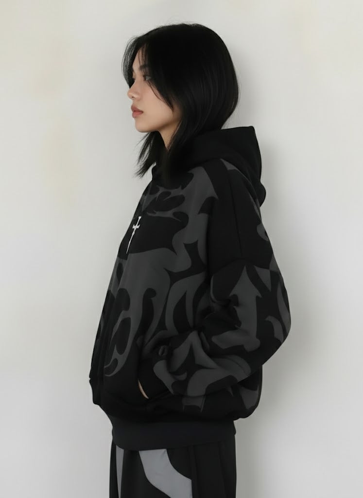 Person wearing a black Depth oversized camouflage hoodie against a white background