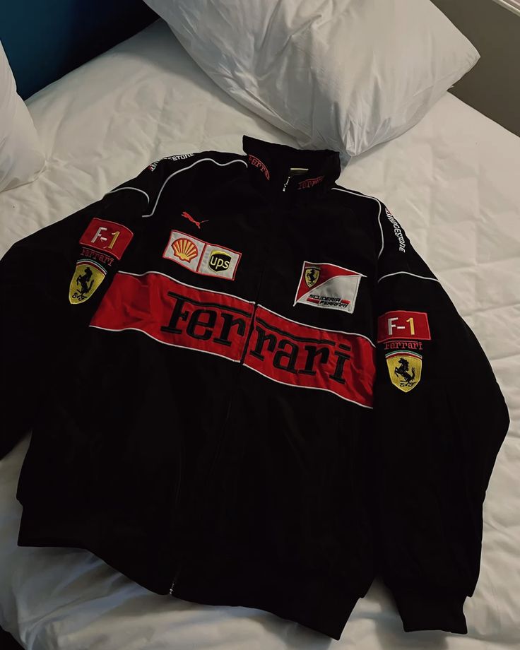 Black Ferrari jacket with logos on a white bed