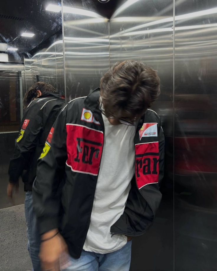 Person wearing a jacket with 'Ferrari' branding in an elevator.