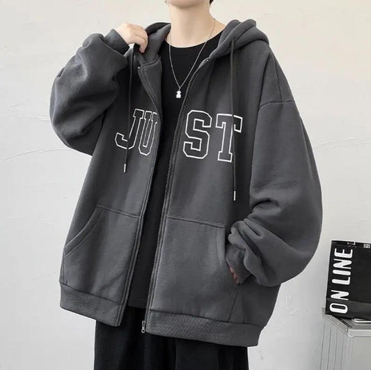 A person wearing a gray hooded sweatshirt with the word 'JUST' printed on the front.